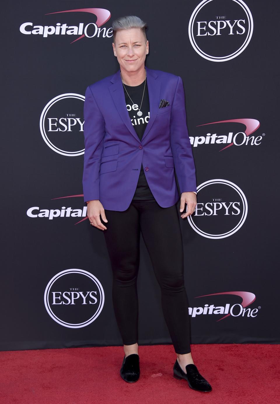 Abby Wambach wearing a purple blazer and velvet loafers