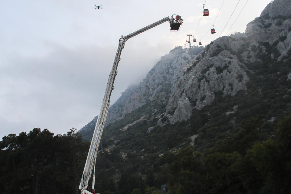 A rescue team work with passengers of a cable car transportation systems outside Antalya, southern Turkey, April, Friday 12, 2024. A cable car disaster in southern Turkey left one person dead and seven injured over the busy Eid al-Fitr public holiday on Friday, local media reported. (IHA via AP)