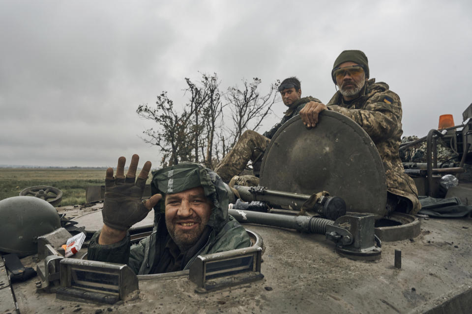 Un soldado ucraniano sonríe desde un vehículo militar el lunes 12 de septiembre de 2022, en el territorio liberado de la región de Járkiv, Ucrania. (AP Foto/Kostiantyn Liberov)