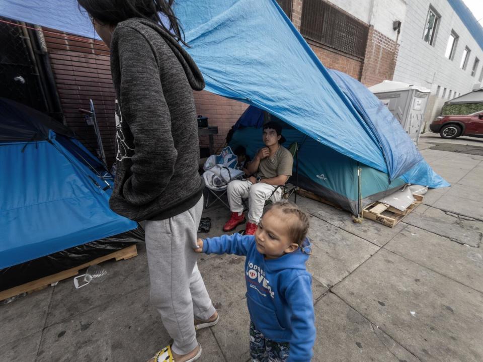 A woman and a child on a sidewalk.