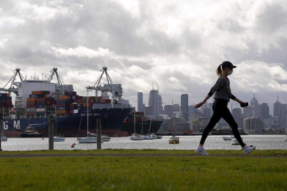 A woman takes a walk in a park during lockdown due to the continuing spread of the coronavirus in Melbourne, Thursday, Aug. 6, 2020. Victoria state, Australia's coronavirus hot spot, announced on Monday that businesses will be closed and scaled down in a bid to curb the spread of the virus. (AP Photo/Andy Brownbill)