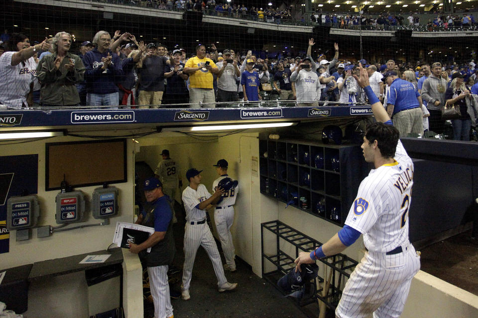 FILE - In this Sept. 7, 2019, file photo, fans cheer as Milwaukee Brewers' Christian Yelich walks off the field after driving in the winning run with a double during the ninth inning of the team's baseball game against the Chicago Cubs in Milwaukee. Major League Baseball players and owners are currently caught in a bitter dispute over how to start amid the coronavirus pandemic. Both sides occasionally mention fans, talking about doing right by them. (AP Photo/Aaron Gash, File)