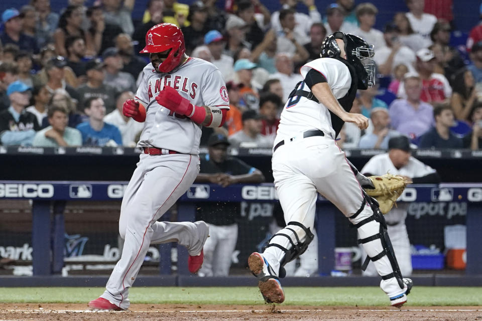 Los Angeles Angels' Jonathan Villar, left, scores past Miami Marlins catcher Jacob Stallings on a single by Shohei Ohtani during the fifth inning of a baseball game Wednesday, July 6, 2022, in Miami. (AP Photo/Lynne Sladky)