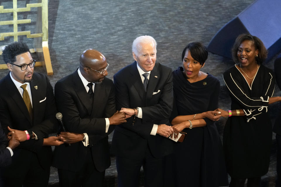 President Joe Biden, center, holds hands with Sen. Raphael Warnock, D-Ga., a senior pastor at Ebenezer Baptist Church, second from left, and Keisha Lance Bottoms, senior adviser to Biden for public engagement and former Atlanta Mayor, second from right, after Biden spoke at Ebenezer Baptist Church in Atlanta, Sunday, Jan. 15, 2023, during a service honoring Martin Luther King Jr. (AP Photo/Carolyn Kaster)