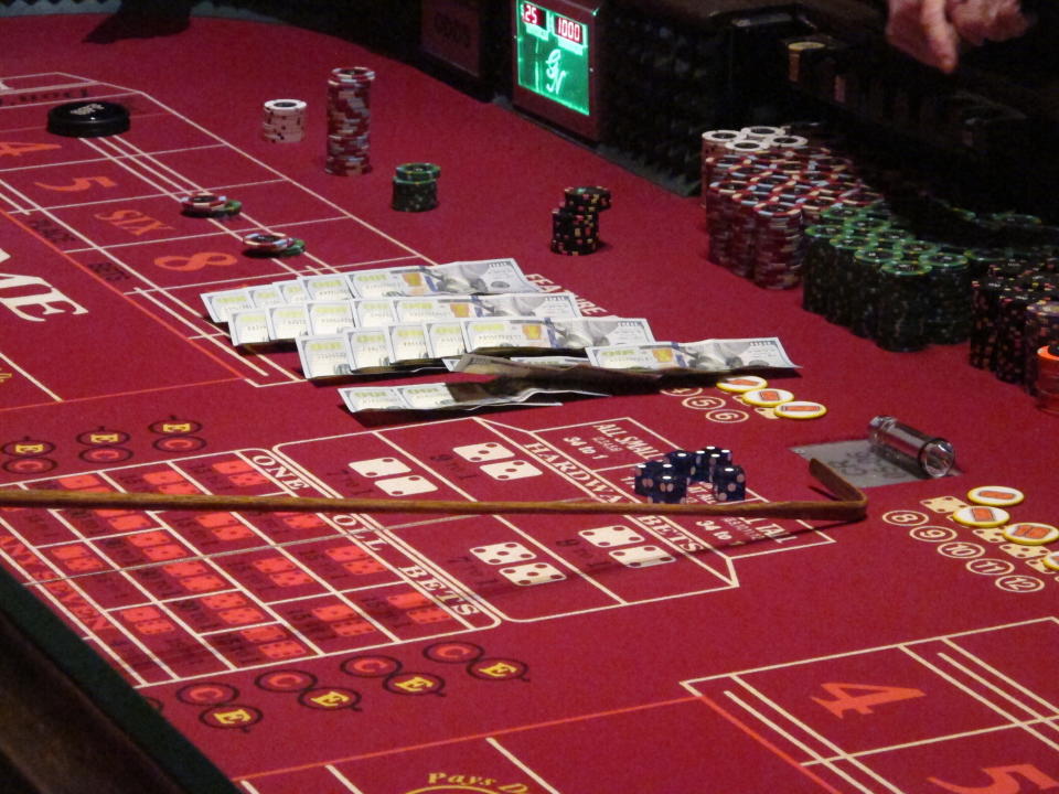 This June 24, 2016 photo shows cash, chips and dice on a craps table during a game at the Golden Nugget casino in Atlantic City, N.J. On June 16, 2020, the American Gaming Association, the casino industry's national trade group, called on state gambling regulators to make it easier for gamblers to use cashless betting options during the coronavirus outbreak. (AP Photo/Wayne Parry)