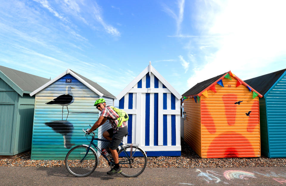 A man cycles past beach huts in Herne Bay, Kent, during the morning sunshine. (Photo by Gareth Fuller/PA Images via Getty Images)