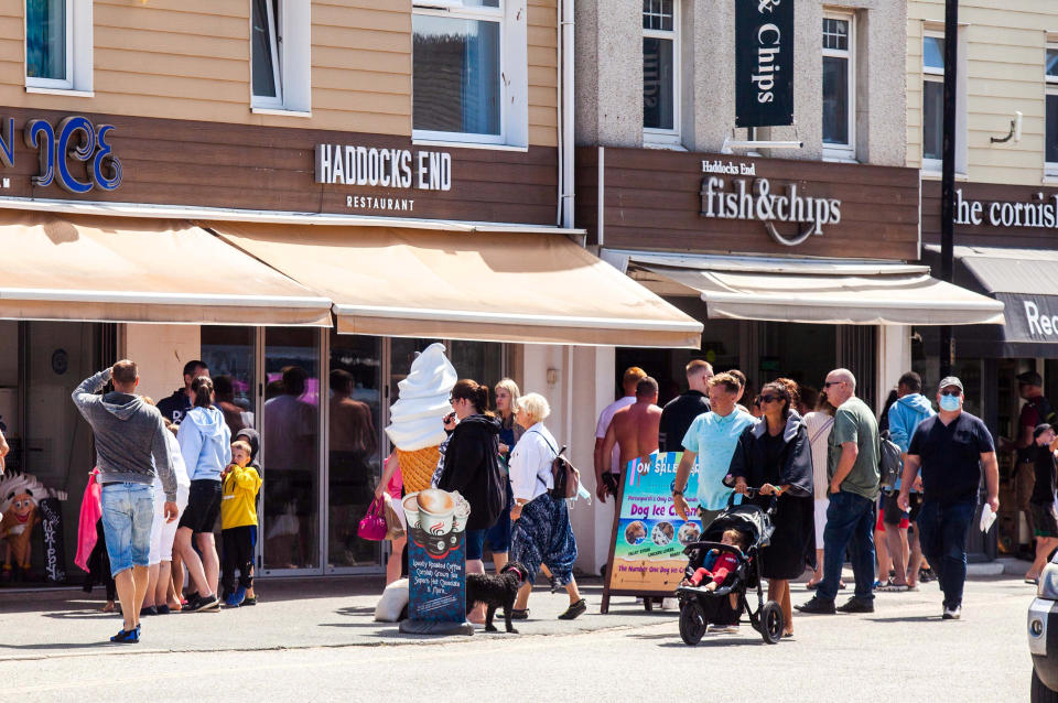 The Perranporth High Street in Cornwall, busy with visitors. 1st August 2020. See SWNS story SWPLtourism; Cornwall residents fear a local lockdown and say they are "scared to leave their houses"  - as some of the county's beaches are likened to "Benidorm on steroids". Some of the more popular seaside destinations along the south-west coast have seen trails of cars queuing through the town as visitors flock to beaches or holiday parks in search of a 'staycation'. But locals in these popular towns have been left feeling "uneasy" about leaving their homes - and some fear they could be in for a local lockdown set to be worse than the first lockdown. Tina-Marie Lally, from Penzance, tried to visit Porthminster Beach in St Ives last week - but shared photos on Facebook of the beach crowded with people and windbreakers.