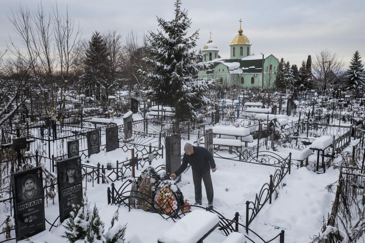 Yuriy Kryvenko visita la tumba de su padre, Oleksandr Kryvenko, asesinado por un soldado ruso en marzo en Bucha, Ucrania, el 4 de diciembre de 2022. (David Guttenfelder/The New York Times)
