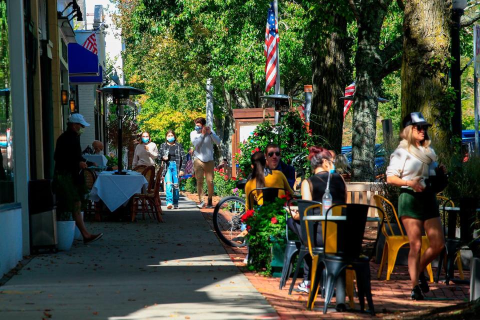 People walk by Main Street in Southampton, New York.