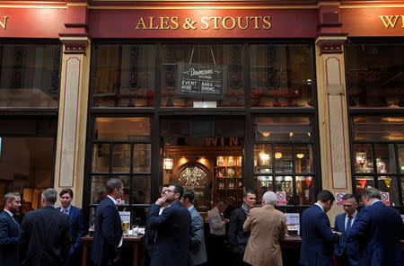 FILE PHOTO: Workers drink outside of a pub in the City of London in London, Britain, October 18, 2017. REUTERS/Toby Melville