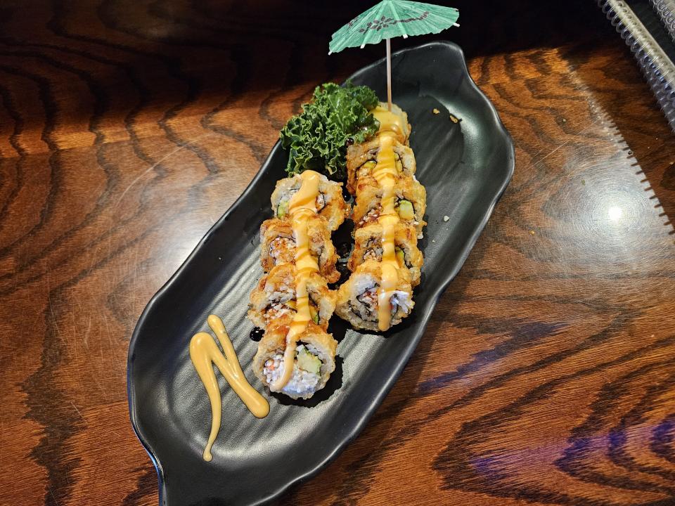 The Golden California is a tempura (fried) roll of imitation crab, avocado and cucumber (with a paper umbrella) at Katsunori Sushi.