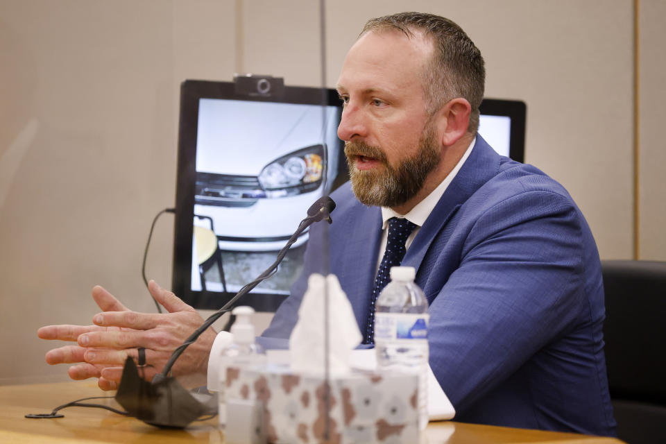 Medical examiner Travis Danielsen answers questions from the prosecution about the autopsy of vicim Lu Thi Harris during the murder trial of Billy Chemirmir at the Frank Crowley Courts Building in Dallas, Tuesday, Nov. 16, 2021. Chemirmir, 48, faces life in prison without parole if convicted of capital murder for smothering Lu Thi Harris, 81, and stealing her jewelry. He is accused of killing at least 18 women in Dallas and Collin counties. (Tom Fox/The Dallas Morning News via AP, Pool)