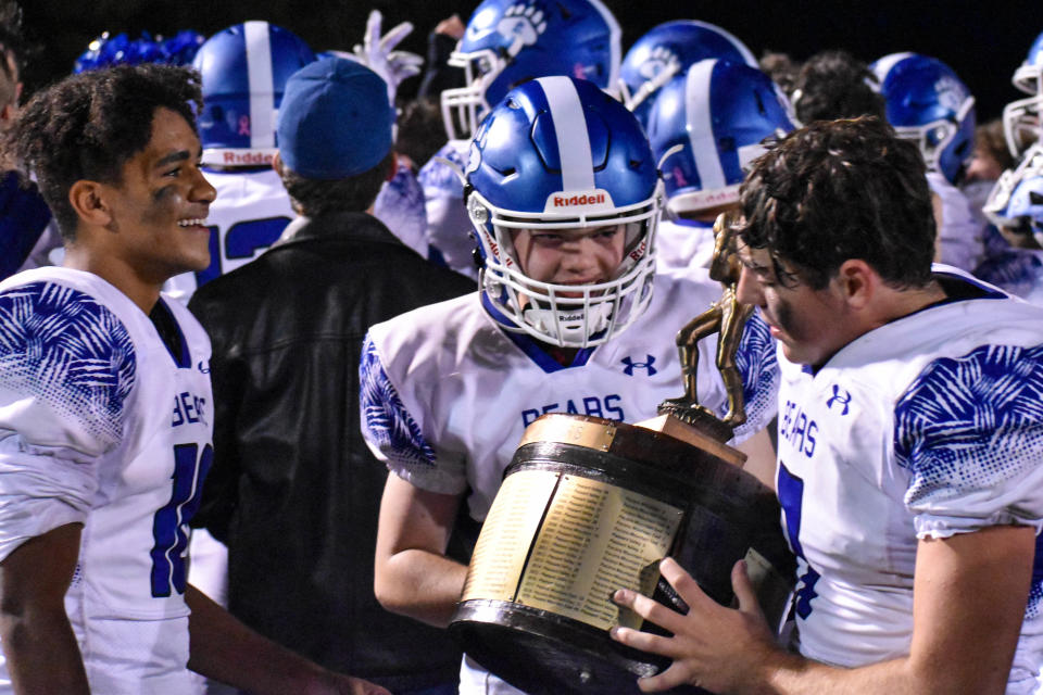 Pleasant Valley football players admire the Old Oaken Bucket trophy in Swiftwater on Friday, Oct. 1, 2021. Pleasant Valley won its rivalry game against Pocono Mountain East, 42-8.