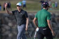 Jan 20, 2019; La Quinta, CA, USA; Adam Long (left) acknowledges the crowd after a putt on the 17th green as Adam Hadwin walks by during the final round of the Desert Classic golf tournament at PGA West - Stadium Course. Mandatory Credit: Orlando Ramirez-USA TODAY Sports