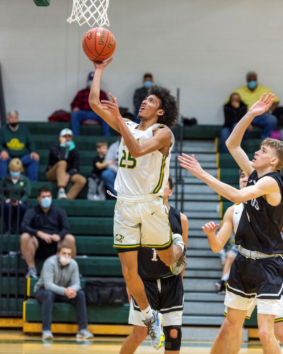 Salina South's Quevon Purucker (25) slips past the Campus defense for a layup Friday night at the South gym.