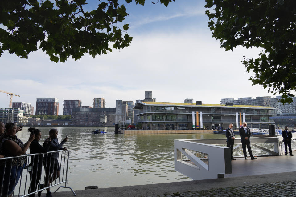 Dutch King Willem-Alexander, right, and Patrick Verkooijen, CEO of the Global Center on Adaptation, left, pose for the cameras prior to the opening ceremony for the Floating Office, rear, where a high-Level dialogue on climate adaptation takes place in Rotterdam, Netherlands, Monday, Sept. 6, 2021. The dialogue, taking place just weeks before the COP26 UN climate change conference in Glasgow, will hammer out a clear call to action for governments, policy-makers and the public on what COP26 must deliver if communities are to be kept safe from the accelerating climate impacts in the coming decade. (AP Photo/Peter Dejong)