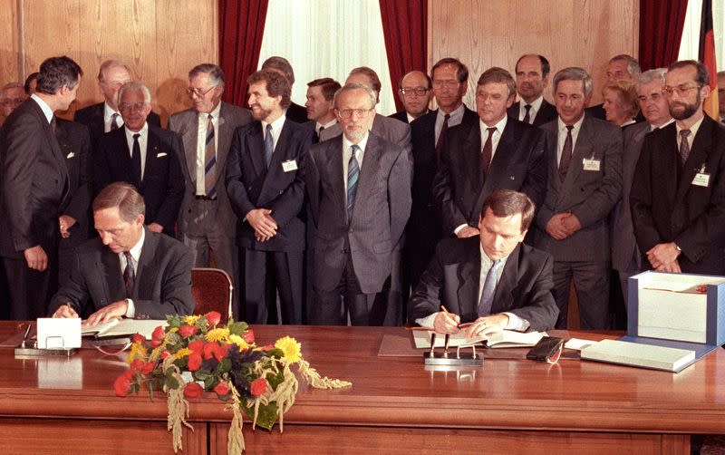 FILE PHOTO: West German Interior Minister Schaeuble and East German Krause sign contract on reunification in East Germany