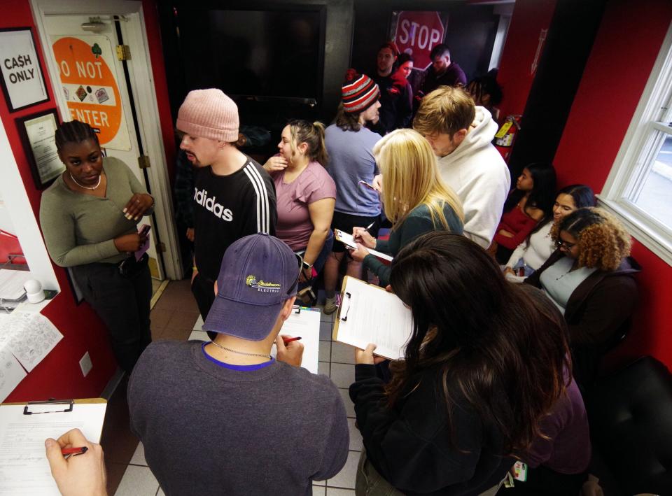 A crowd fills out forms as they wait to take advantage of Friday the 13th tattoo special pricing at the K&M Tattoo Studio in Brockton on Friday, Oct. 13, 2023.