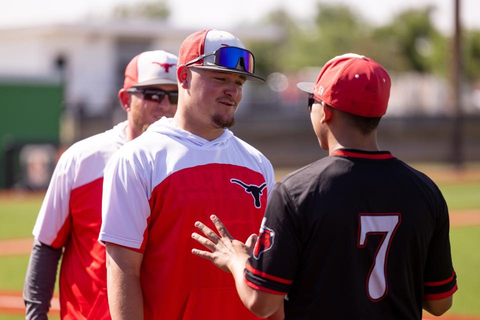 Lockney head coach Payton Rhodes (left) has a discussion with Pablo Morales (7) during the second game of a Class 2A playoff series, Friday, May 13, 2022, against Gruver at Caprock High School in Amarillo.