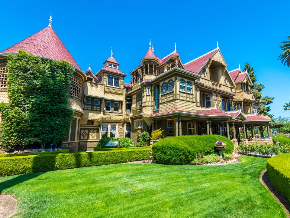 front of the winchester house with green grass in front