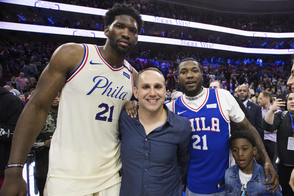 FILE - Philadelphia 76ers' Joel Embiid, of Cameroon, poses for a photo with 76ers' co-owner Michael Rubin, center left, Rapper Meek Mill, center right, and his son, right, after Game 5 of a first-round NBA basketball playoff series between the Miami Heat and the Philadelphia 76ers, Tuesday, April 24, 2018, in Philadelphia. Fanatics founder Michael Rubin is selling his stake in the ownership company that owns the Philadelphia 76ers and New Jersey Devils. (AP Photo/Chris Szagola, File)