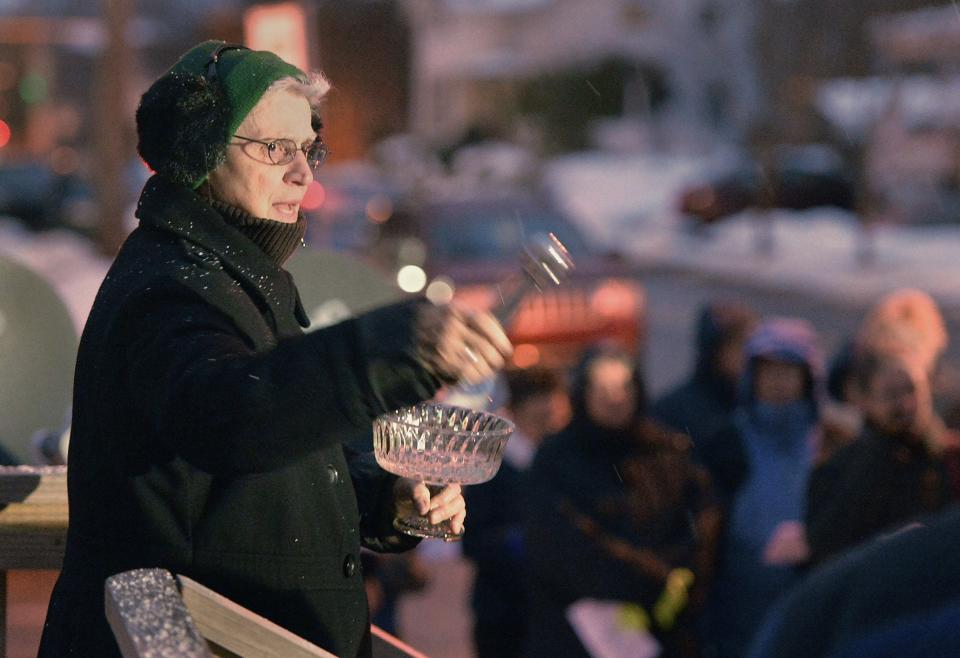 On Nov. 13, 2018, during a prayer vigil held for homicide victim Phillip Anthony Clark, Mary Paul, of the Sisters of Mercy, sprinkles holy water outside the West 29th Street residence where Clark, 44, was shot to death on Sept. 4, 2018.