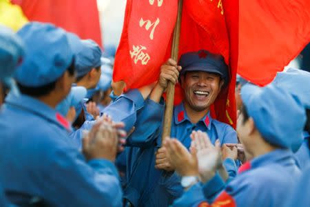 Participants dressed in replica red army uniforms welcome team mates as they return from a hike through the mountains during a Communist team-building course extolling the spirit of the Long March outside Jinggangshan, Jiangxi province, China, September 14, 2017. REUTERS/Thomas Peter