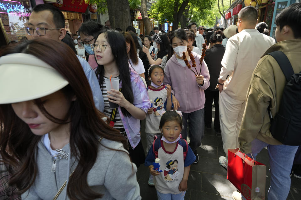 Residents enjoy a day at the popular Nanluogu alleyway during the May Day holidays in Beijing, Monday, May 1, 2023. (AP Photo/Ng Han Guan)