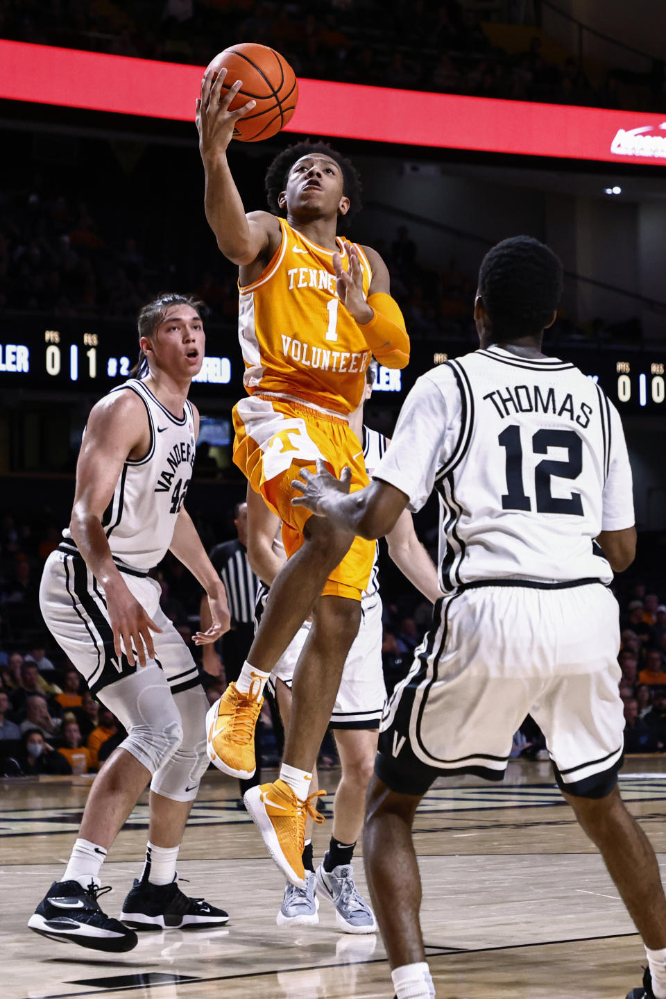 Tennessee guard Kennedy Chandler (1) shoots between Vanderbilt guard Trey Thomas (12) and forward Quentin Millora-Brown (42) during an NCAA college basketball game Tuesday, Jan. 18, 2022, in Nashville, Tenn. (AP Photo/Wade Payne)