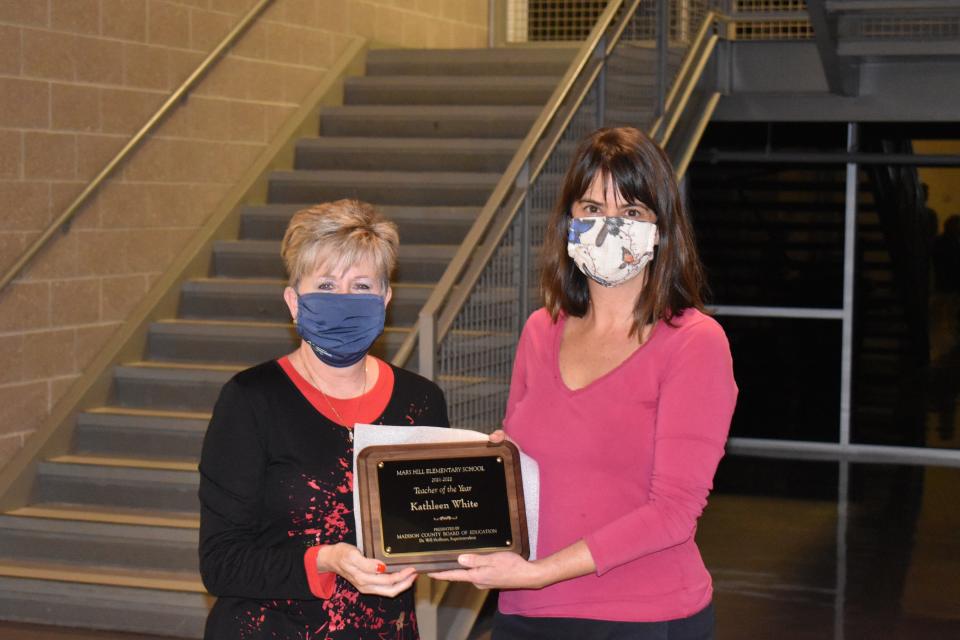 Katie White receives a plaque from Madison County Board of Education chair Karen Blevins recognizing her as Mars Hill Elementary School's 2021-22 Teacher of the Year.