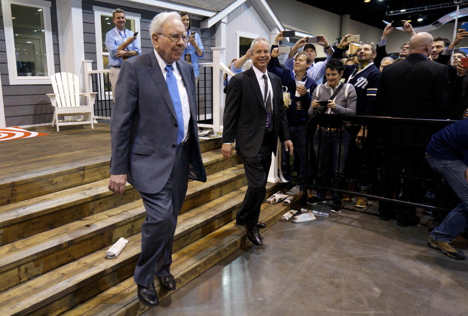 Berkshire Hathaway CEO Warren Buffett (L) walks with Kevin T. Clayton, CEO of Berkshire Hathaway subsidiary Clayton Homes, out of one of the company's houses prior to the Berkshire annual meeting in Omaha, Nebraska May 2, 2015.  Billionaire investor Buffett on Saturday defended his Clayton Homes unit against accusations that the manufactured home seller had preyed on lower-income purchasers with its lending practices. REUTERS/Rick Wilking