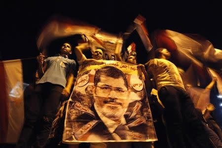 MURSI: Muslim Brotherhood backers hold a banner of deposed Egyptian President Mohamed Mursi at a protest against his overthrow in July 2013. REUTERS/Mohamed Abd El Ghany