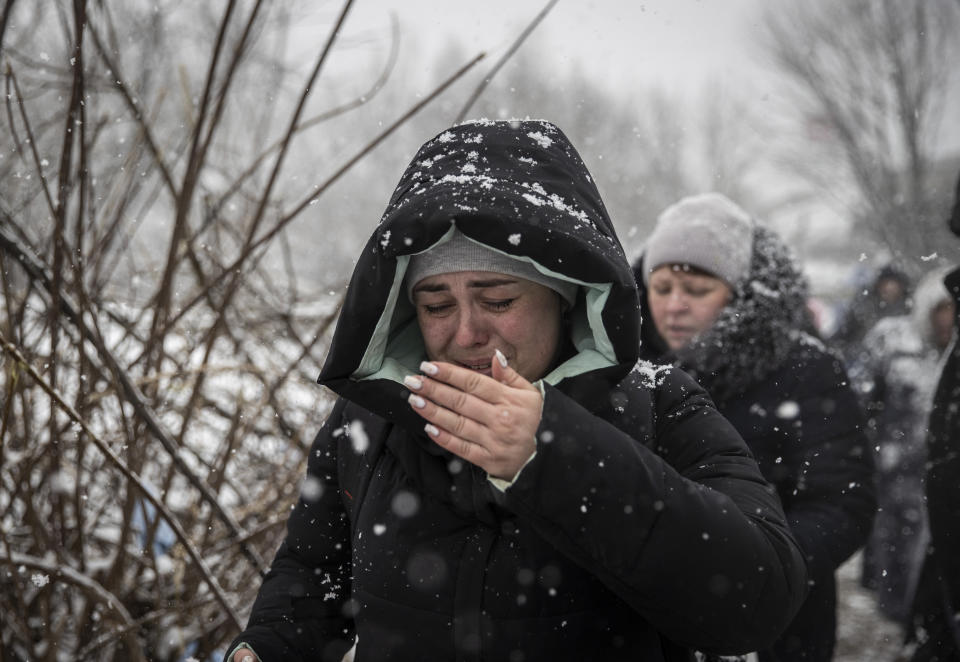 Civilians flee ongoing Russian attacks as snow falls in Irpin.