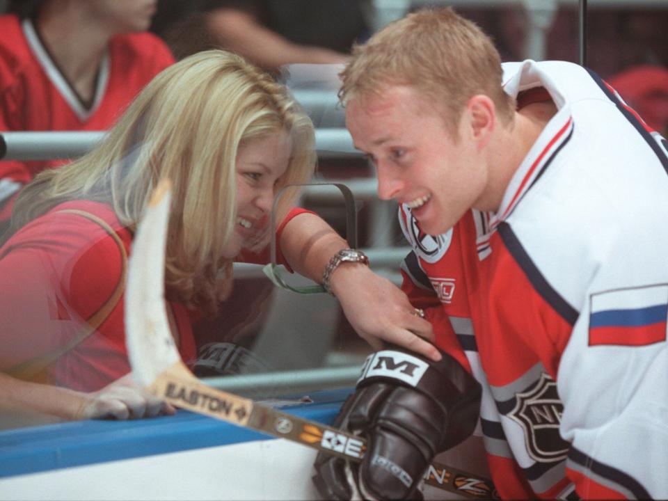 Valerie Bure speaks to his pregnant wife, Candace Cameron, through a hole in the glass after today's all-star game
