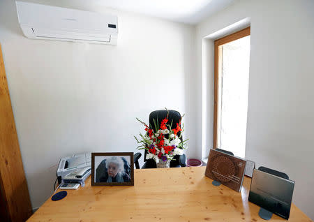 A photograph of late Nancy Hatch Dupree, an American historian, and a bouquet of flowers are seen in her office after she passed away, in Afghanistan Centre at Kabul University (ACKU), in Kabul, Afghanistan September 10, 2017. REUTERS/Mohammad Ismail