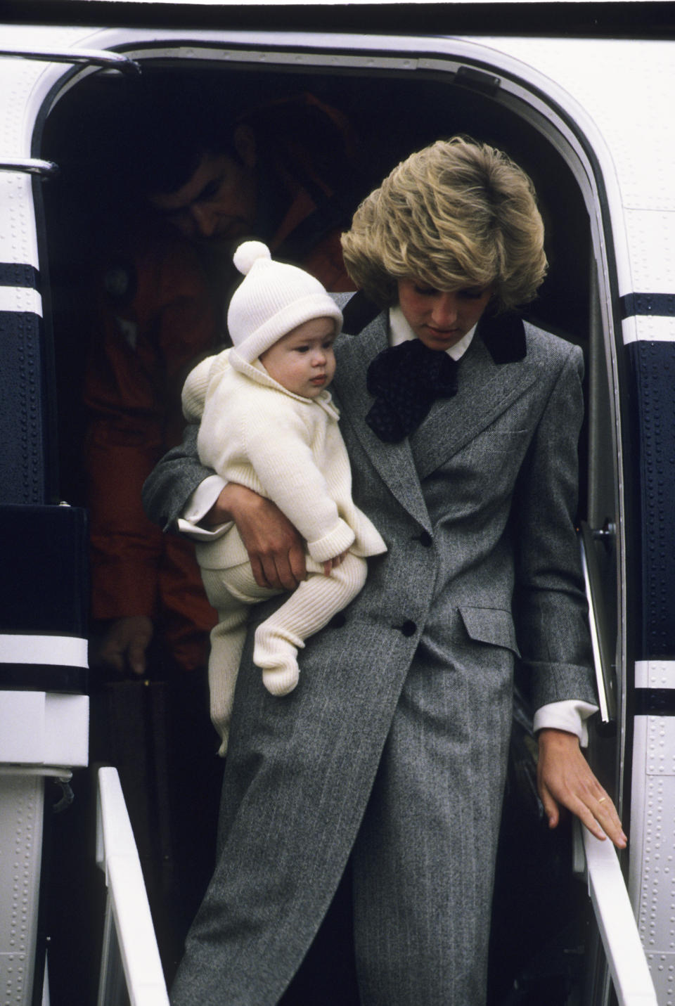 Diana, Princess of Wales carries her son, Prince Harry, off a flight at Aberdeen Airport