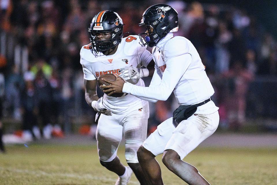 Hawthorne Hornets Cj Ingram (7) hands the ball off to Hawthorne Hornets Keenon Johnson (9) during the first half between Williston High School and Hawthorne High School at Williston High School in Williston, FL on Friday, November 24, 2023. [Chris Watkins/Gainesville Sun]