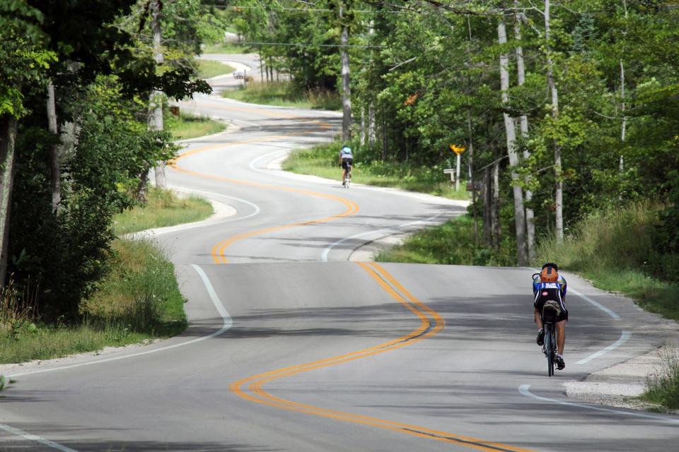 Bicyclists enjoy the winding road up Highway 42 in Door County.