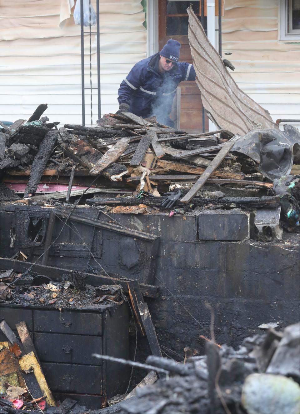 A fire official inspects the scene of a fatal fire on Spaulding Avenue in Newcomerstown.