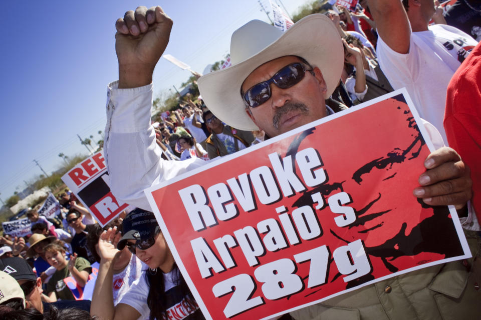 A man holds up sign calling for the Department of Homeland Security to revoke the Maricopa County Sheriff's authority under the 287(g) program to investigate immigration crimes, in Phoenix, Ariz., Feb. 28, 2009