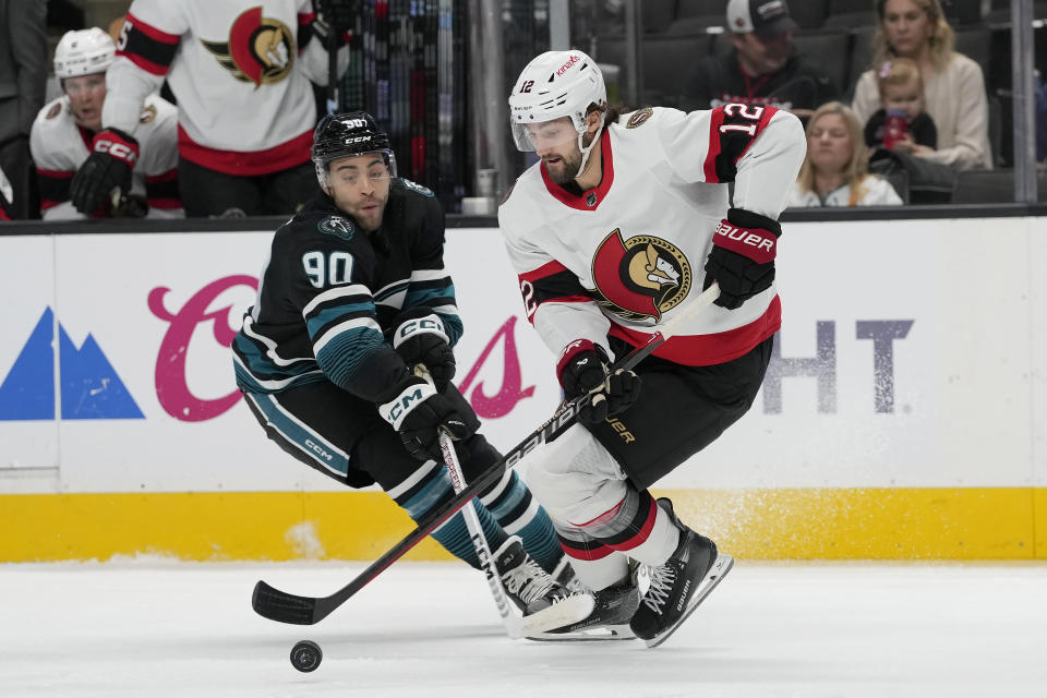 Ottawa Senators center Mark Kastelic (12) skates with the puck against San Jose Sharks right wing Justin Bailey (90) during the first period of an NHL hockey game in San Jose, Calif., Saturday, March 9, 2024. (AP Photo/Jeff Chiu)