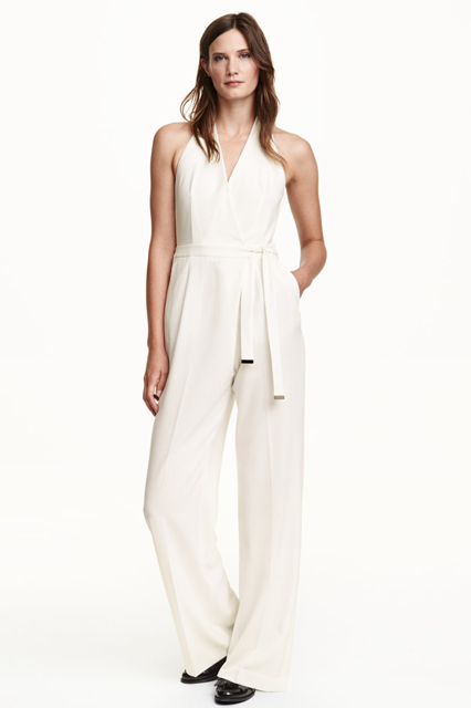 It’s all in the details with this jumpsuit. Simple eye tricks, like a halter top, a front-wrap tie at the waist, and wide pant legs give this piece a luxe feel.