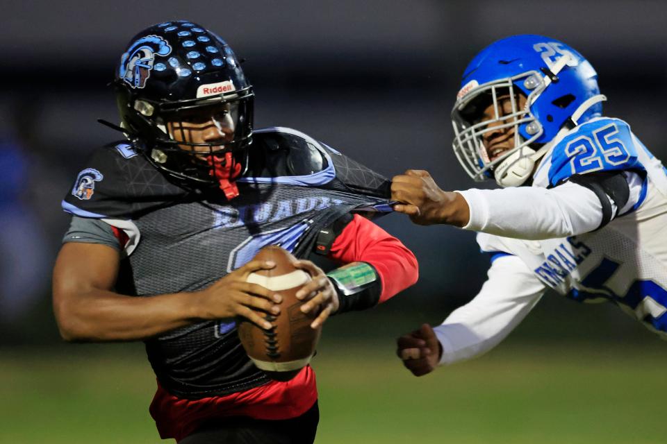 Ribault's quarterback Timothy Cole (2) is pressured by Riverside's Ivan Brown (25) during the first quarter.