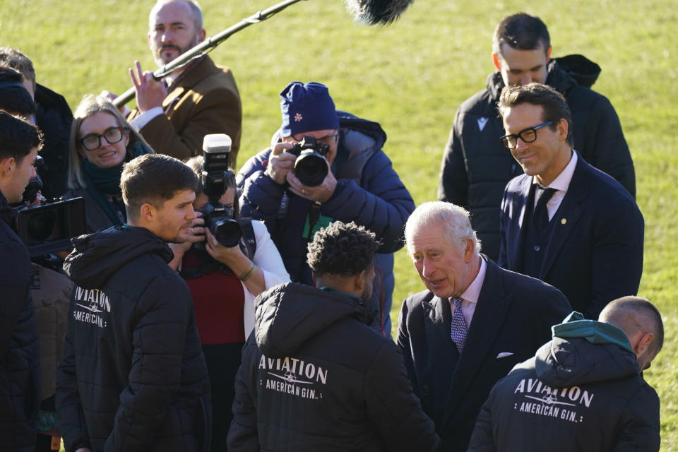 Wrexham Soccer team co owner, US actors Ryan Reynolds, watches as Britain's King Charles III meets players during a visit to Wrexham Association Football Club's Racecourse Ground, in Wrexham, England, Friday, Dec. 9, 2022. (Jacob King/PA via AP)