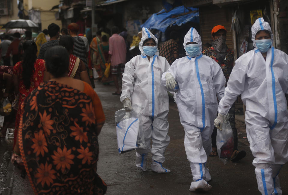 Health workers return after screening people for COVID-19 symptoms in Dharavi, one of Asia's biggest slums, in Mumbai, India, Tuesday, Aug. 11, 2020. India has the third-highest coronavirus caseload in the world after the United States and Brazil. (AP Photo/Rafiq Maqbool)