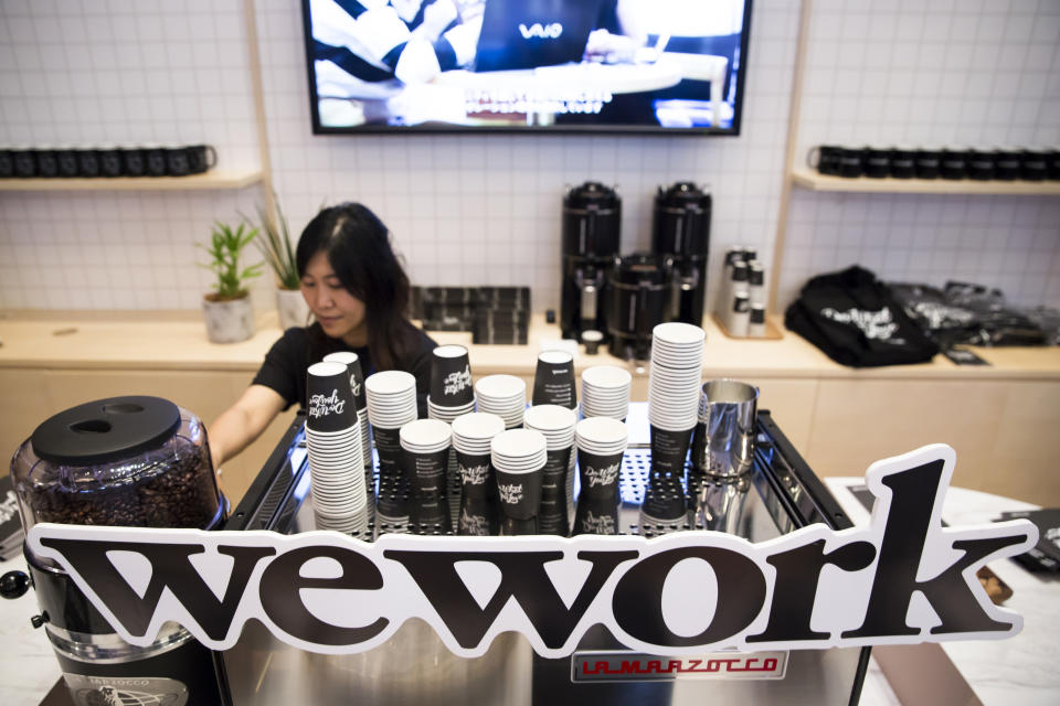 TOKYO, JAPAN - JULY 19:  An employee is seen behing the logo of WeWork Companies Inc. during the SoftBank World 2018 conference on July 19, 2018 in Tokyo, Japan. The annual business event hosted by SoftBank, Japan's multinational telecommunications and internet company, takes place for 2 days until July 20.  (Photo by Tomohiro Ohsumi/Getty Images)