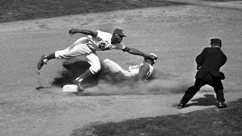 April 10, 1962: Dodger second baseman Jim Gilliam makes a stop on Daryl Spencer's wide throw as Tommy Harper slides safely into second during the sixth inning.