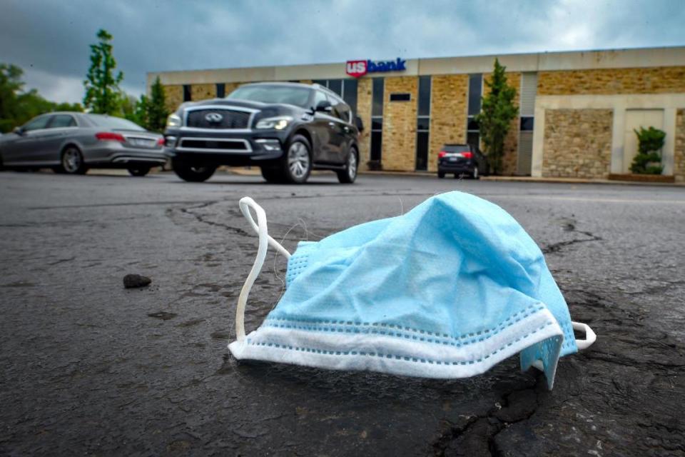 A discarded mask rests in the parking lot outside of the U.S. Bank in the Prairie Village Shopping Center.