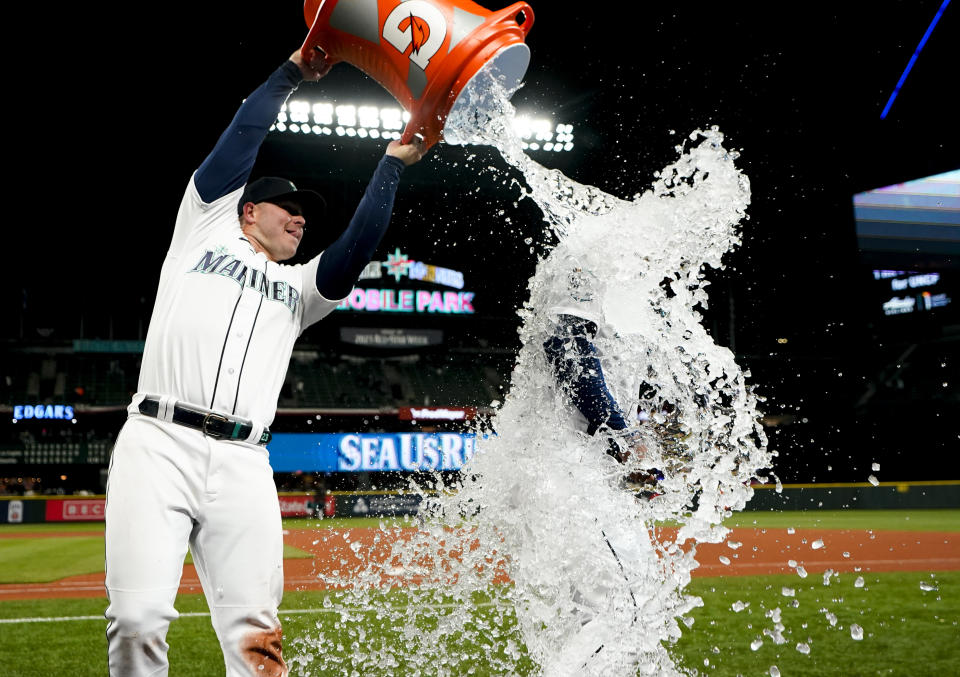 Seattle Mariners first baseman Ty France douses Teoscar Hernandez, who had hit two home runs against the Los Angeles Angels in a baseball game Tuesday, April 4, 2023, in Seattle. (AP Photo/Lindsey Wasson)