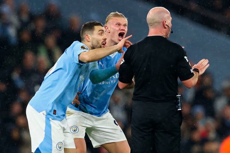 Mateo Kovacic y Erling Haaland le protestan al árbitro Simon Hooper durante el partido de Premier League entre Manchester City y Tottenham; por estos reclamos el City debió pagar una multa 